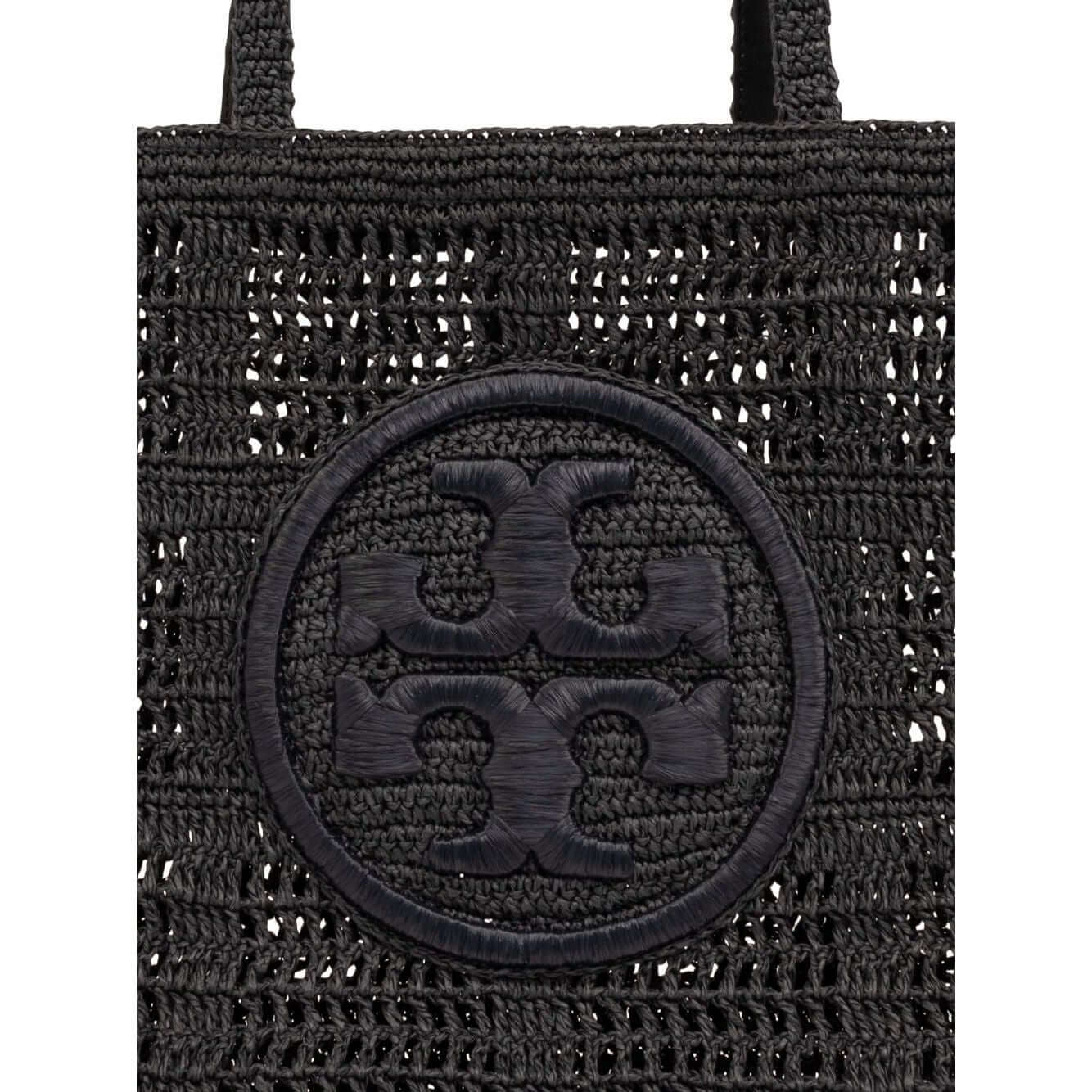 Close-up of Tory Burch Large Ella Crochet Tote Bag in black raffia with Double T logo and top handles, highlighting woven design.