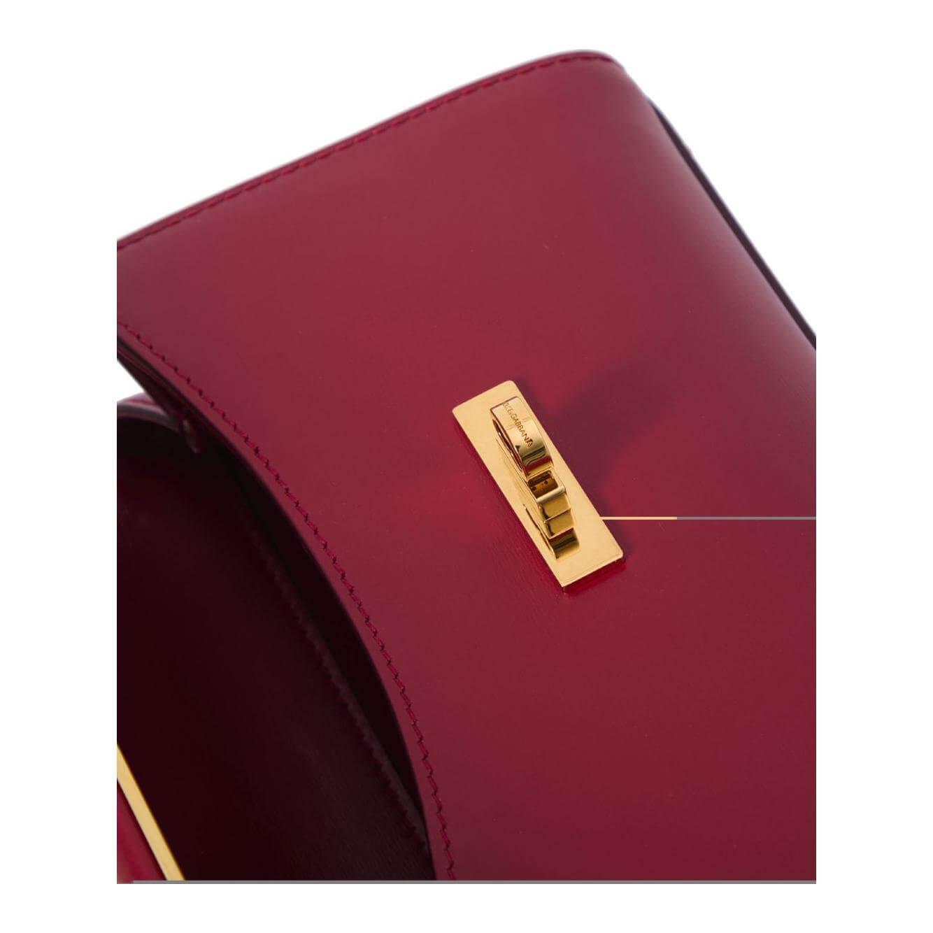 Close-up of Dolce & Gabbana red mini Marlene shoulder bag with gold turn-clasp fastening.