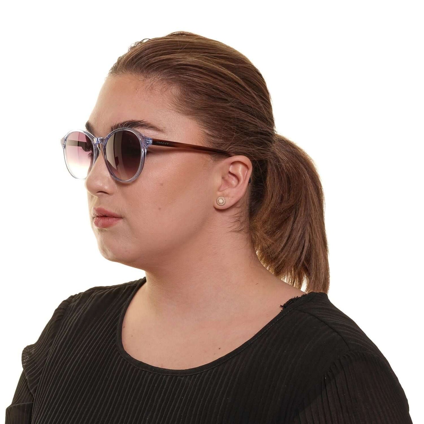 Woman wearing Gant blue sunglasses with brown gradient lenses, full-rim plastic frame, 100% UV protection, round style.