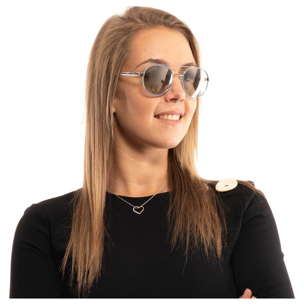 Woman wearing Guess turquoise aviator sunglasses with mirrored lenses and metal frame, featured in profile.