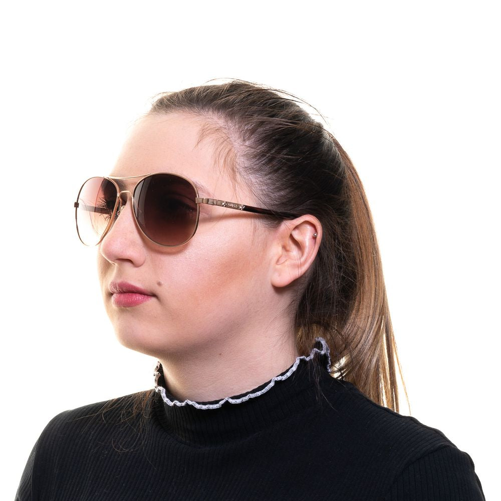 Woman wearing Guess gold aviator sunglasses with brown gradient lenses and metal frame.