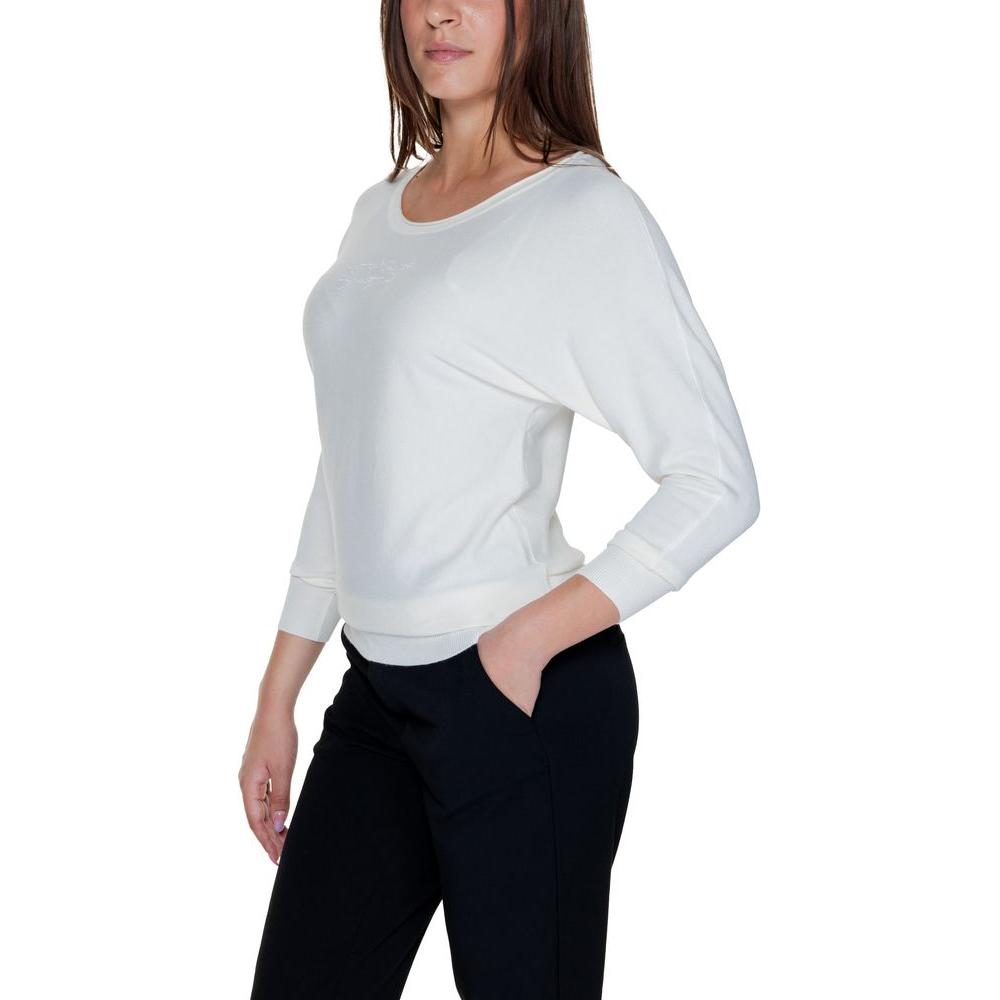 Woman wearing Guess white viscose top from Fall/Winter collection, side view, showcasing long sleeves and comfortable fit.