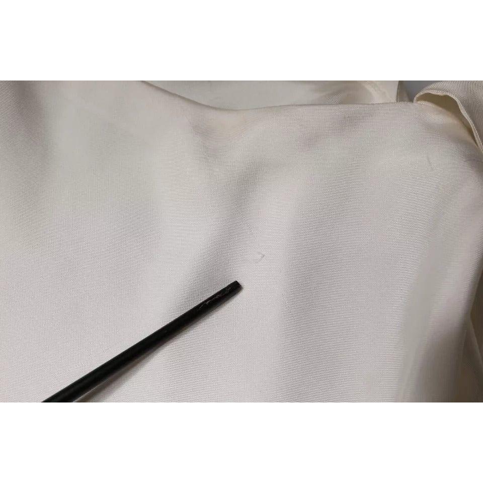 Close-up of fabric showing pulled threads on a beige Brunello Cucinelli silk top with black pointer indicating defect.