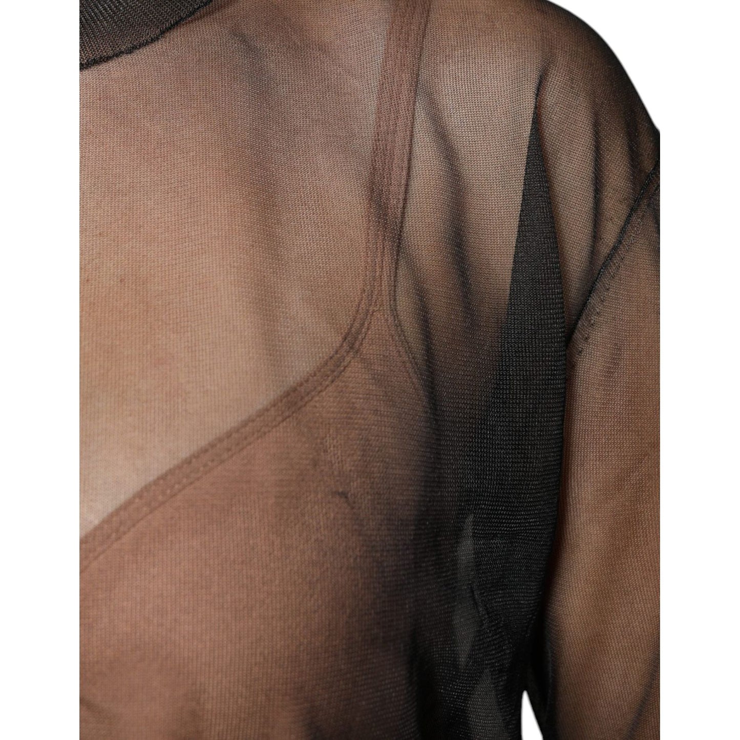 Close-up of a Dolce & Gabbana black sheer crewneck blouse with long sleeves, showing detailed craftsmanship and minor thread pulls.