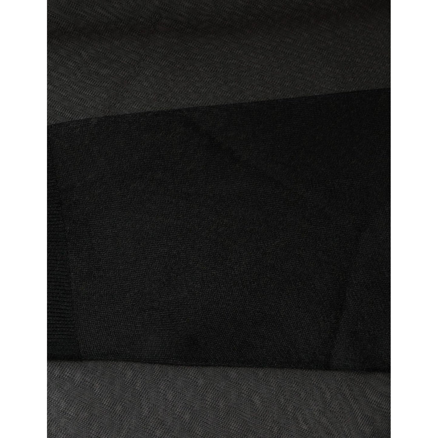 Close-up of Dolce & Gabbana black sheer blouse fabric showing texture, with pulled threads visible, highlighting craftsmanship detail.