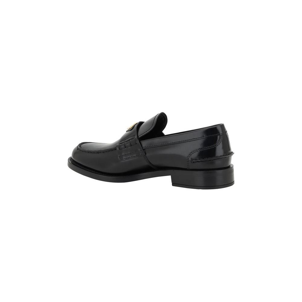 Prada Logo Loafers with leather block heel and iconic enameled plaque, offering classic elegance and distinctive style.