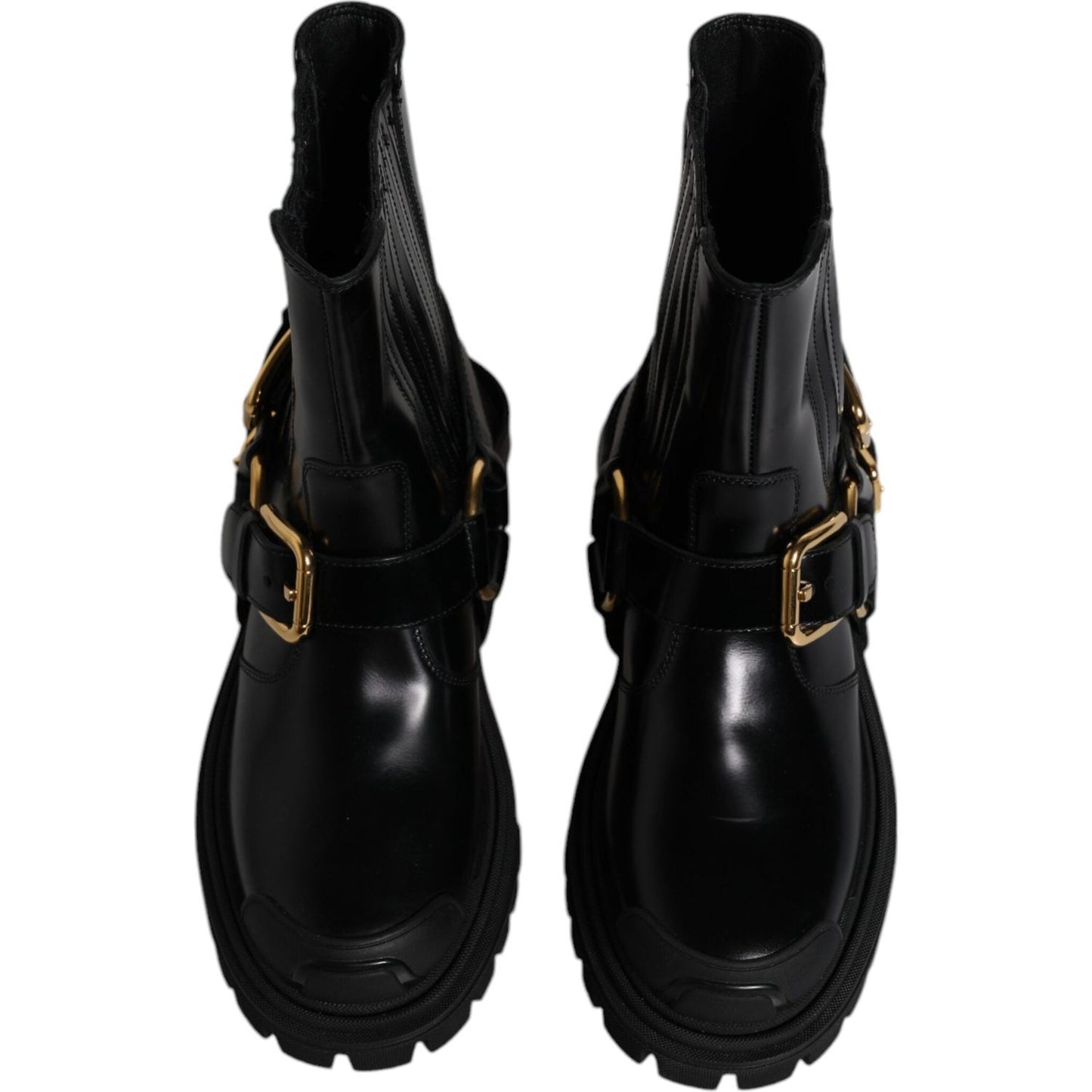 Dolce & Gabbana black leather slip-on trekking boots with gold detailing, mid-calf design, rubber sole, and minor scratches on right shoe.