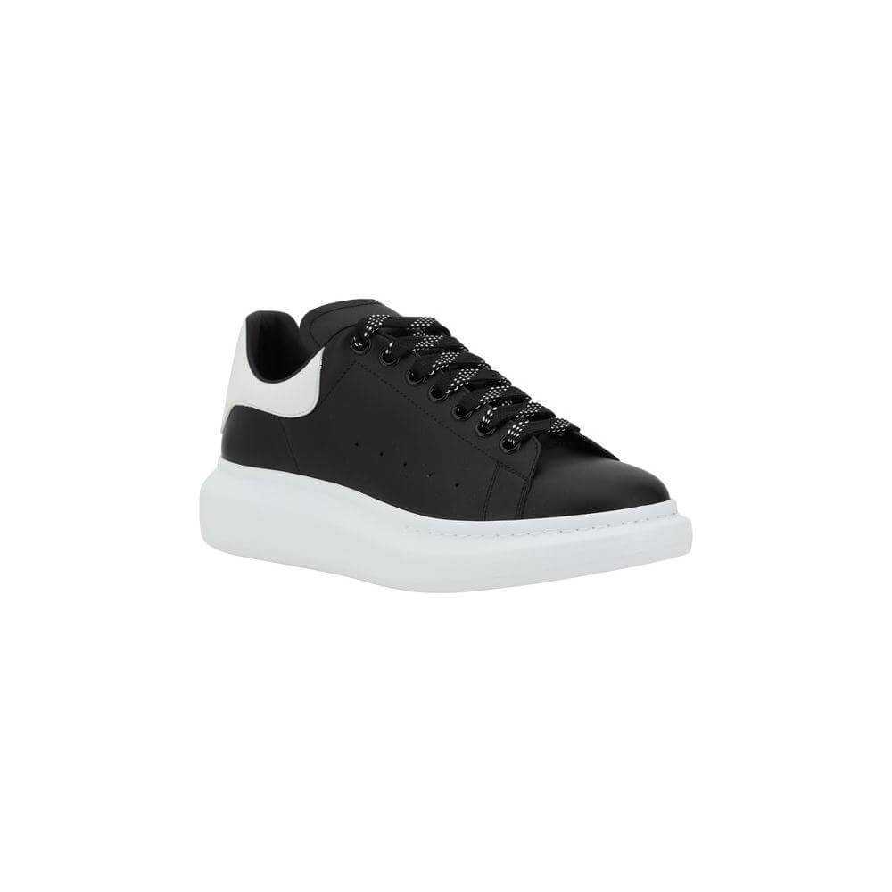 Alexander McQueen black and white leather sneakers with lace-up closure and platform sole.