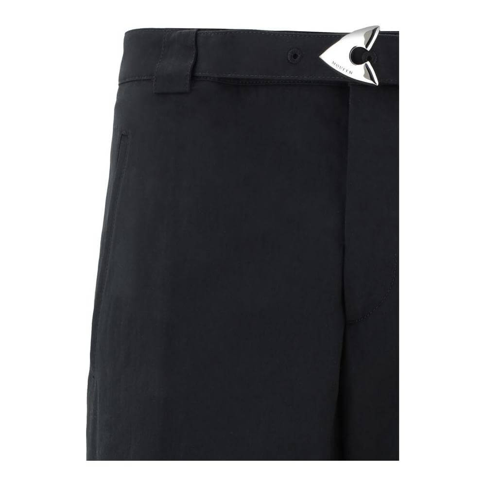 Close-up of Alexander McQueen Arrow Belted Pants showing arrow buckle and waistband detail.