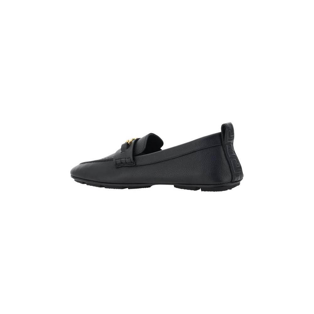 Black Versace leather driver loafers with metallic Medusa detail on front and Greca motif on back tongue, side view.