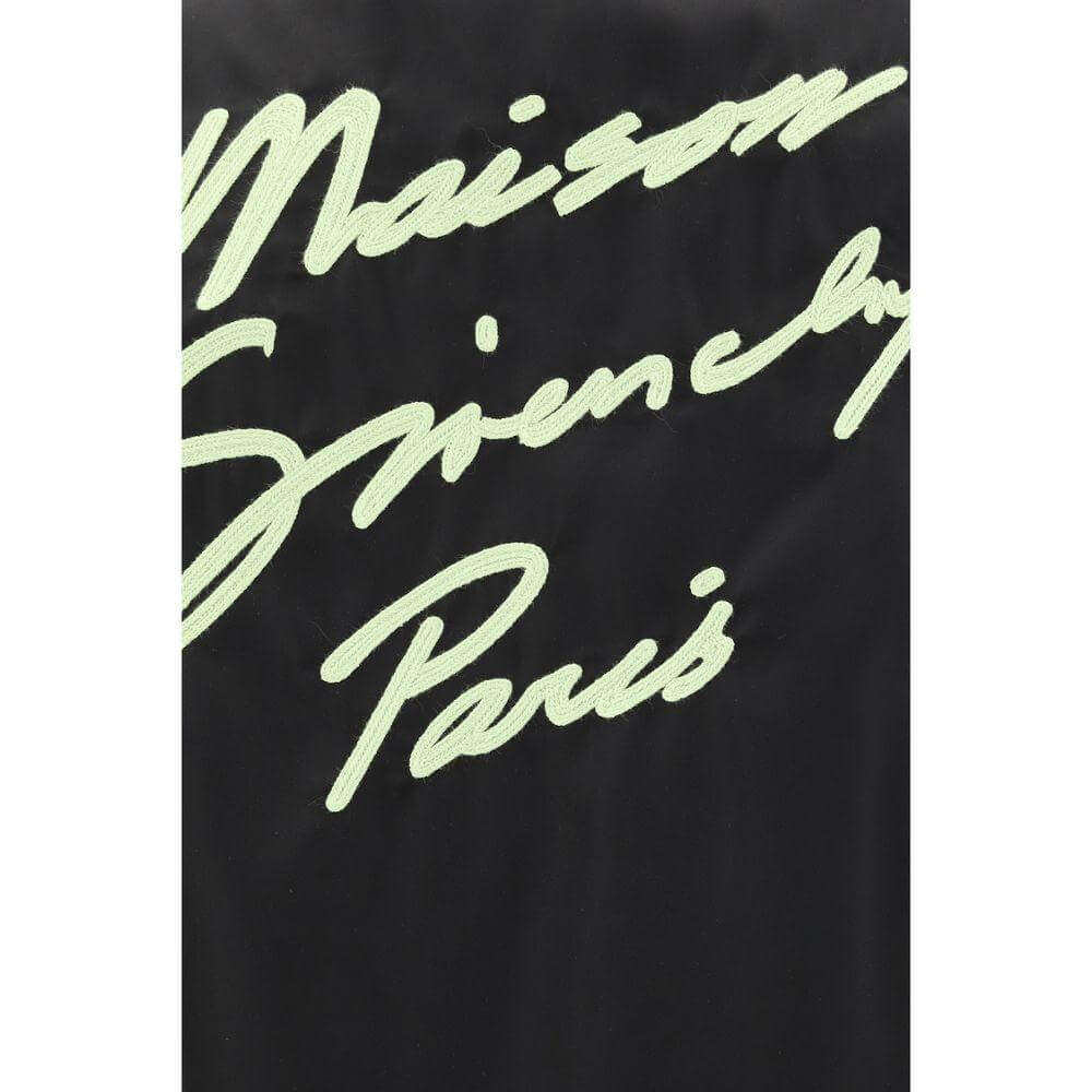 Maison Givenchy Paris monogram embroidery in contrasting color on black oversized shirt background.