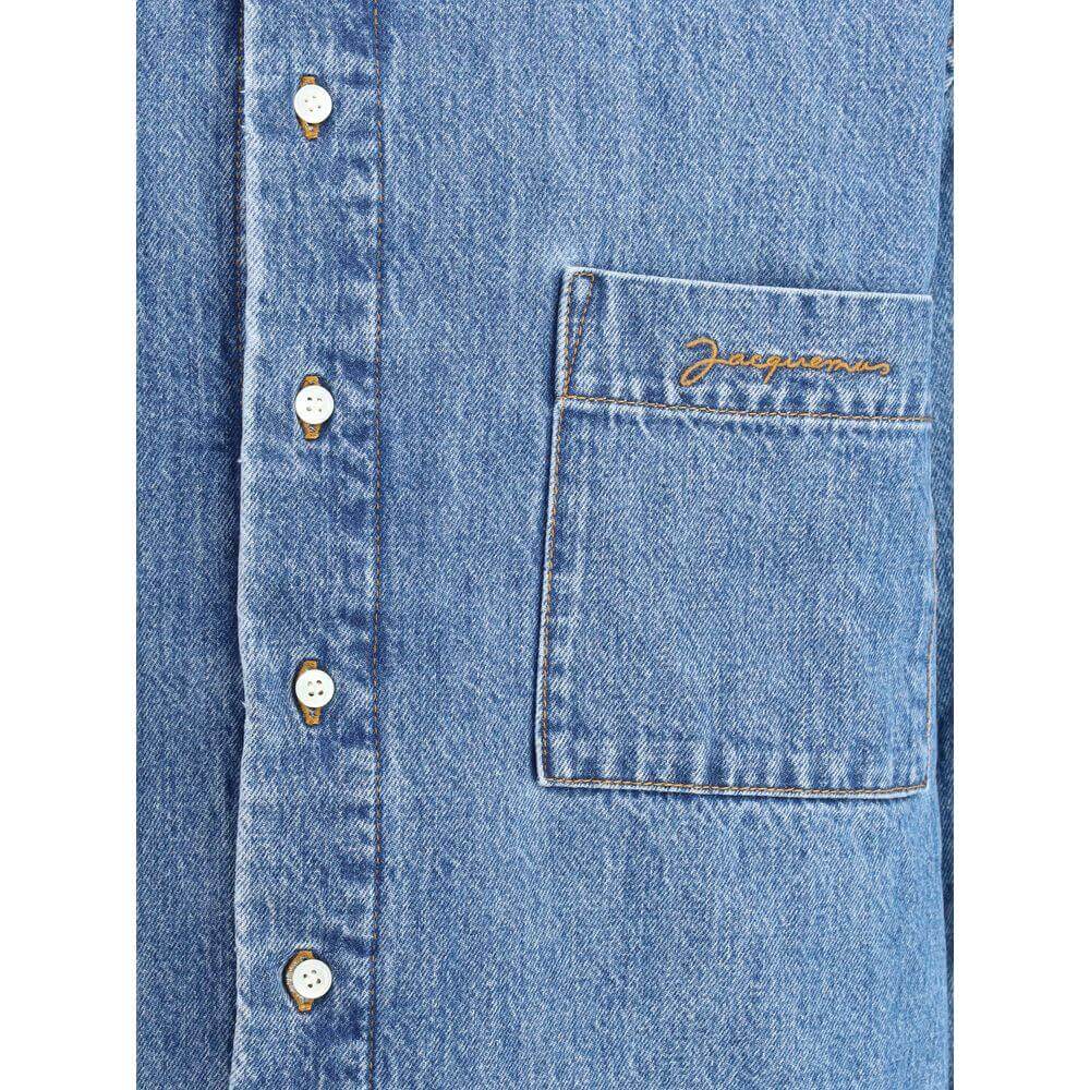 Jacquemus La Chemise Boulanger denim shirt jacket with monogrammed pocket and button closure, showcasing detailed craftsmanship.