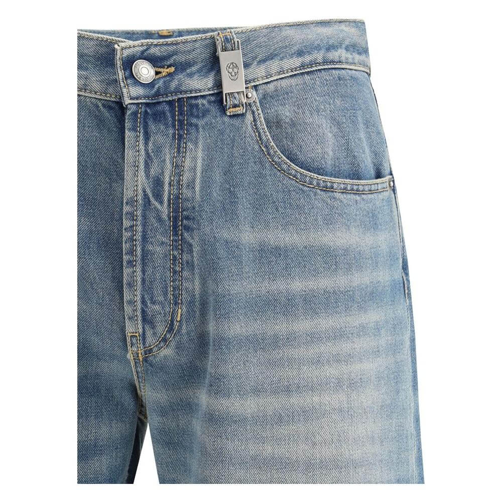 Close-up of Alexander McQueen straight jeans with iconic skull logo plaque, high waist, and classic five-pocket style.