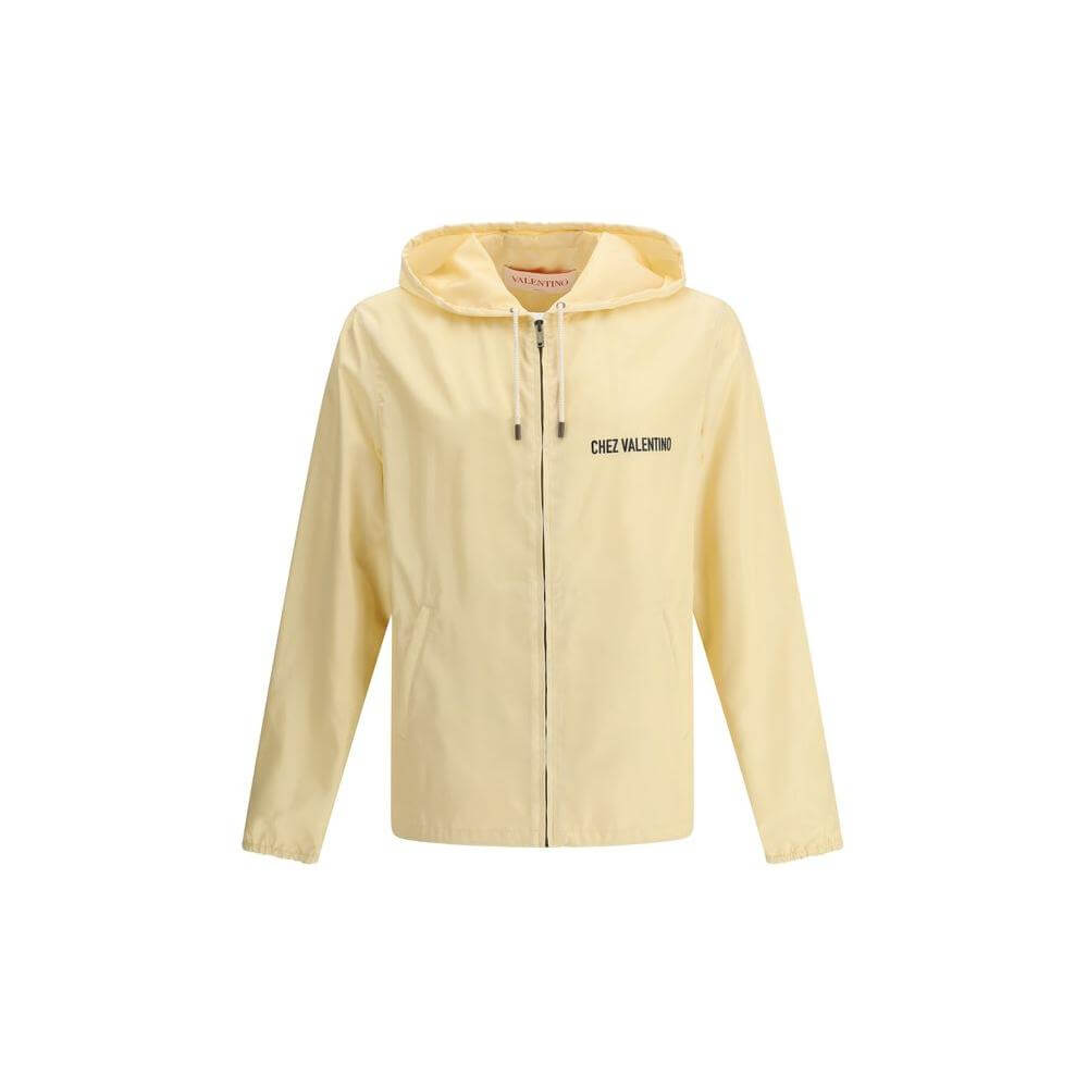Valentino waterproof jacket with hood, front zipper, side pockets, and logo on front and back in light yellow.