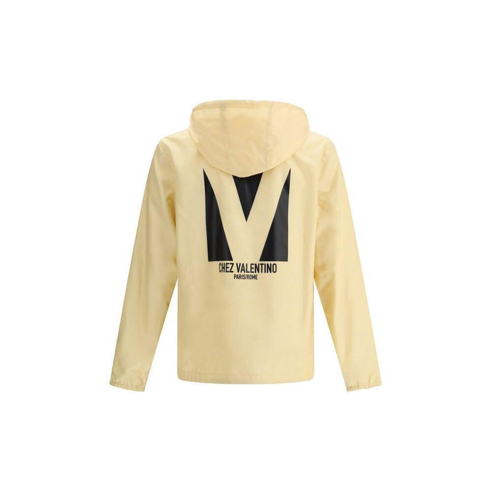 Valentino waterproof jacket in beige with hood, black monogram and logo on back, perfect for stylish rain protection.