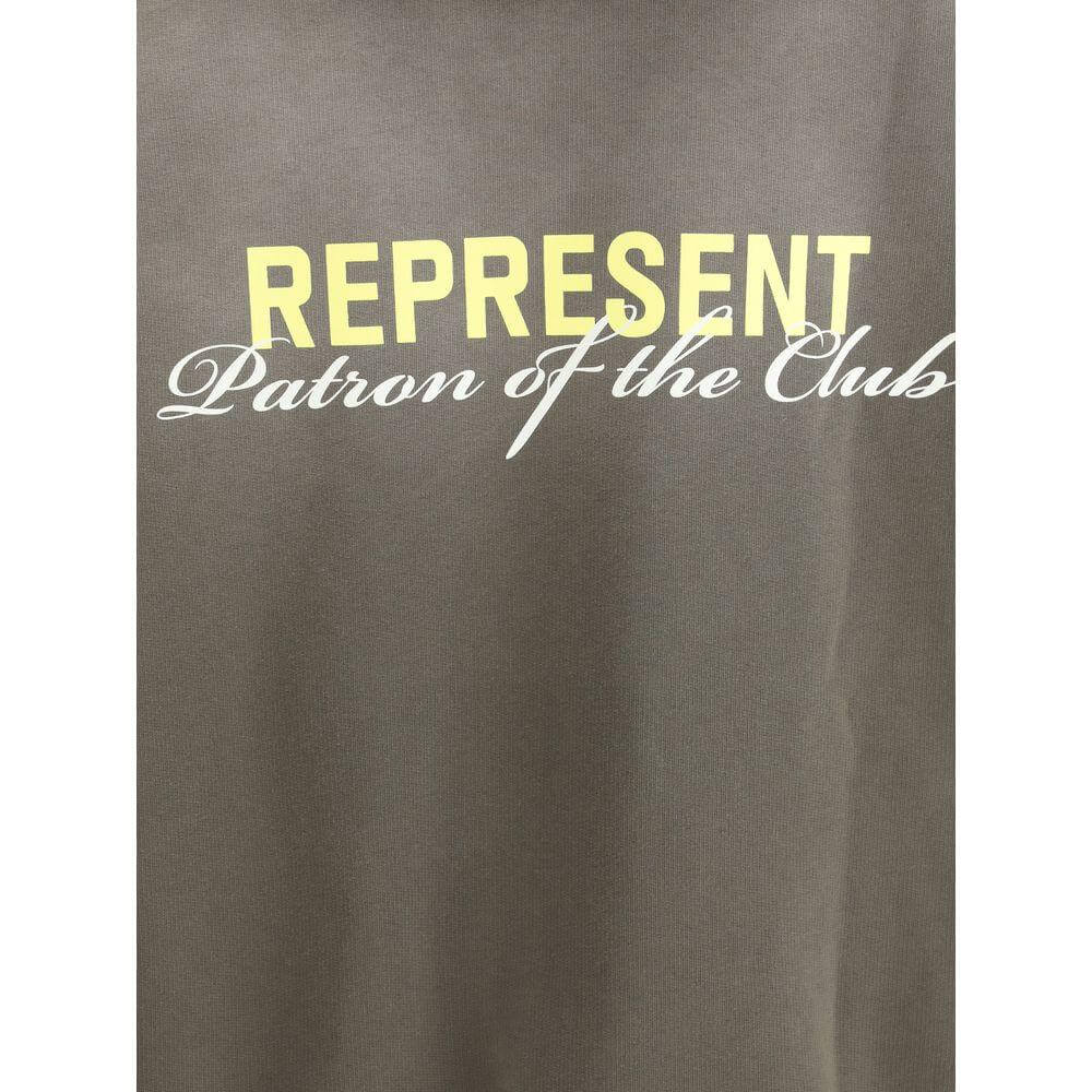 Close-up of Represent hoodie with "Patron of the Club" text and yellow monogram on cotton fabric.