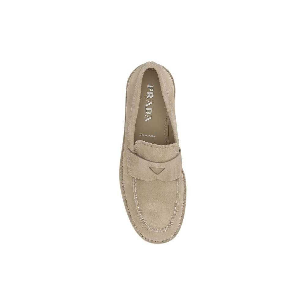 Prada suede loafers in beige with almond toe, flat sole, and logo-embossed insole, offering a sophisticated and modern design.