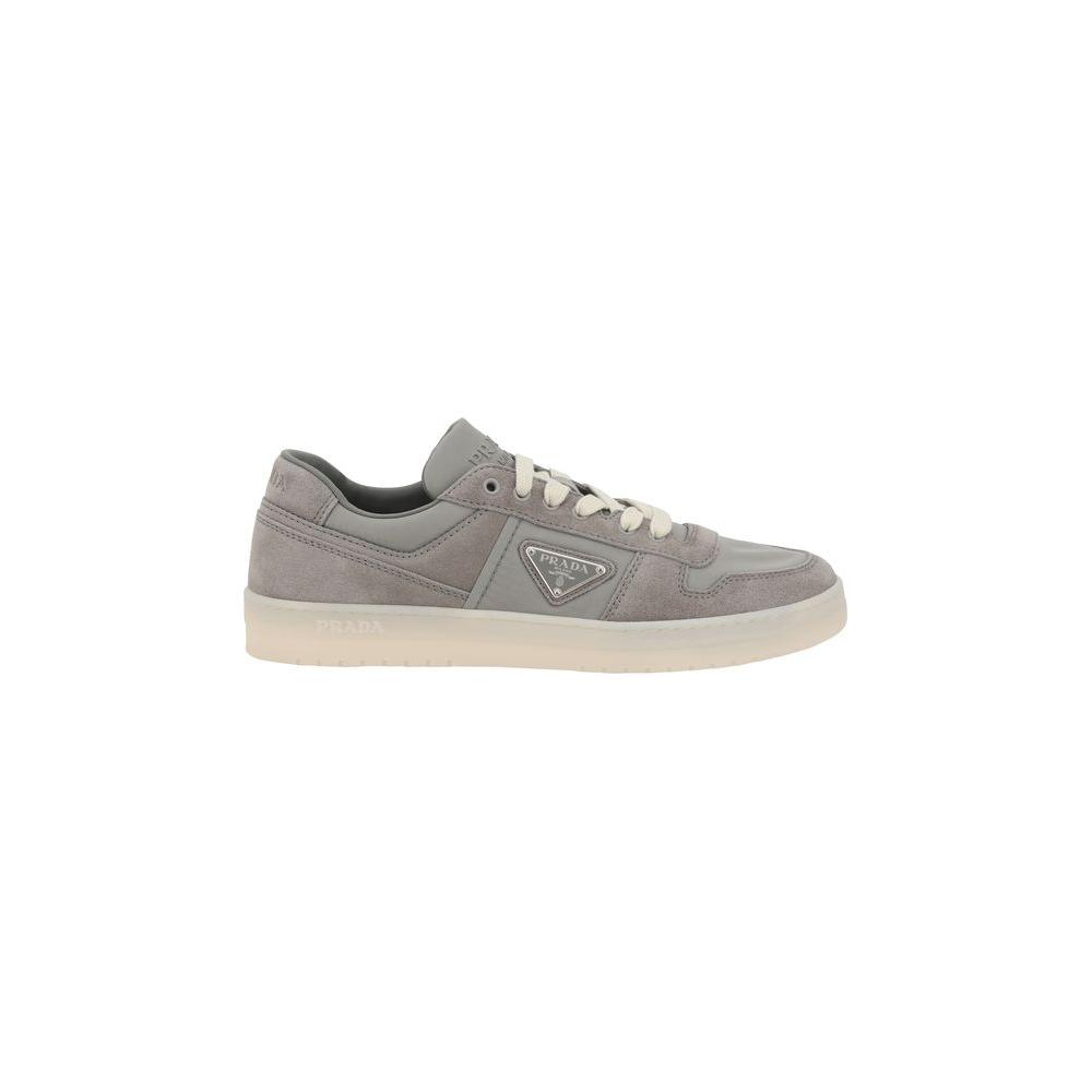 Side view of gray Prada suede leather sneakers with lace-up closure and flat sole, showcasing discreet elegance and comfort.