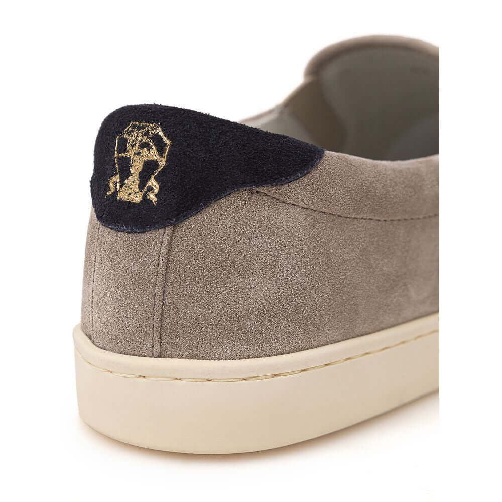 Back view of Brunello Cucinelli Tortora Suede Slip On Sneaker with black detail and gold 'Solomei' print on white rubber sole.