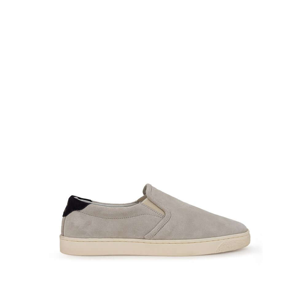 Brunello Cucinelli gray leather sneaker with round toe and white rubber sole, featuring black and gold Solomei print detail, slip-on design.
