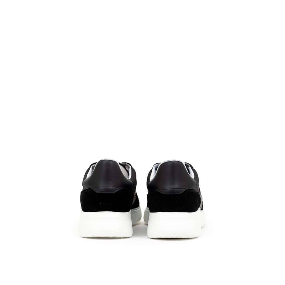 Back view of Axel Arigato Genesis Vintage Runner sneakers in black and white, featuring a leather and suede finish with a modern sole.
