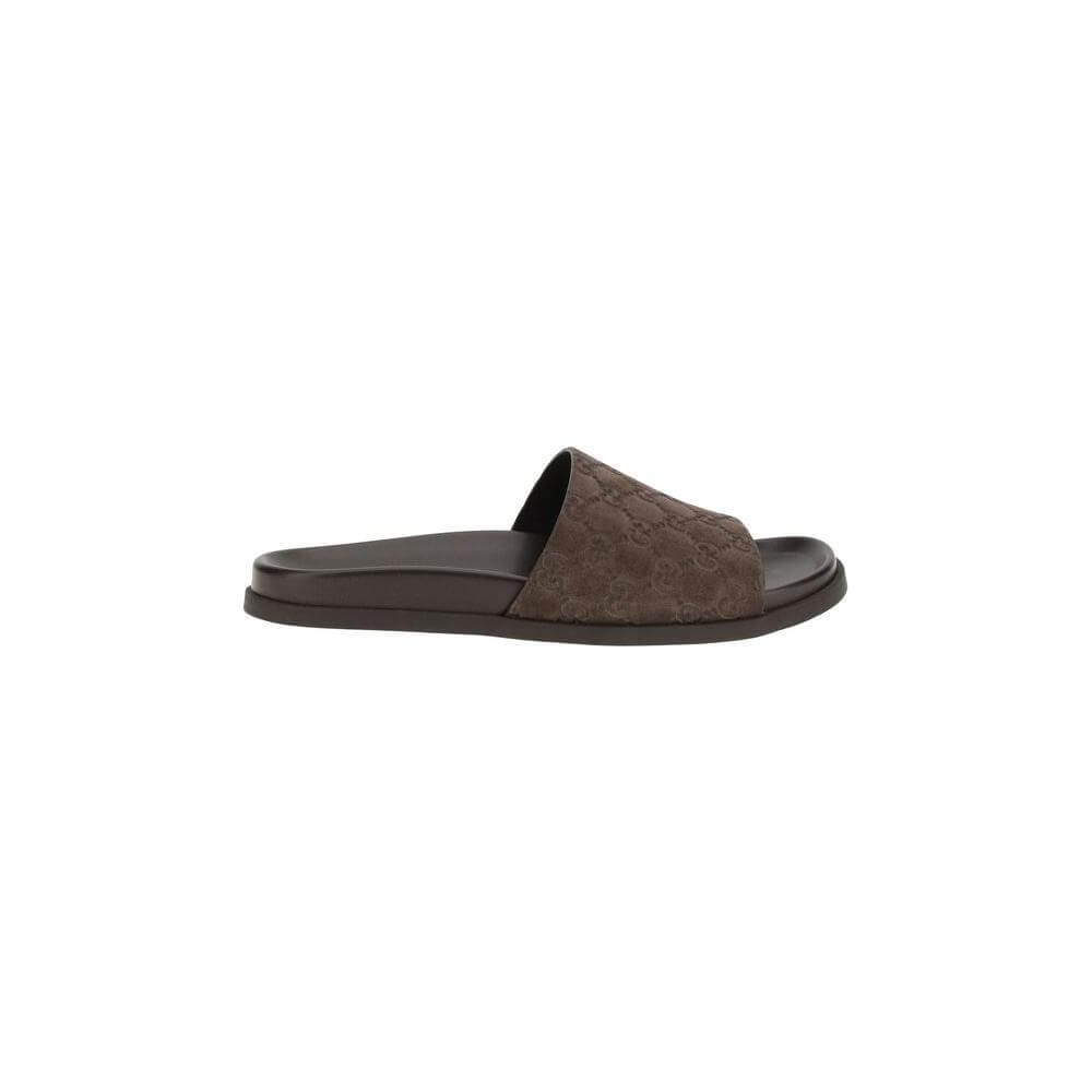 Brown Gucci slider sandal with GG motif, featuring soft suede upper and contoured sole for comfort and elegance.