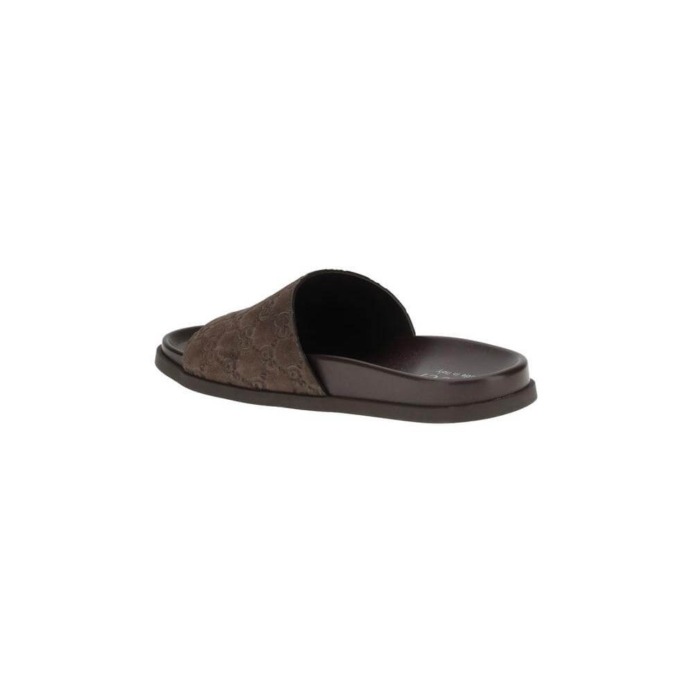 Gucci slider sandals with GG motif, featuring a soft suede upper and contoured sole for comfort and elegance in a summer look.