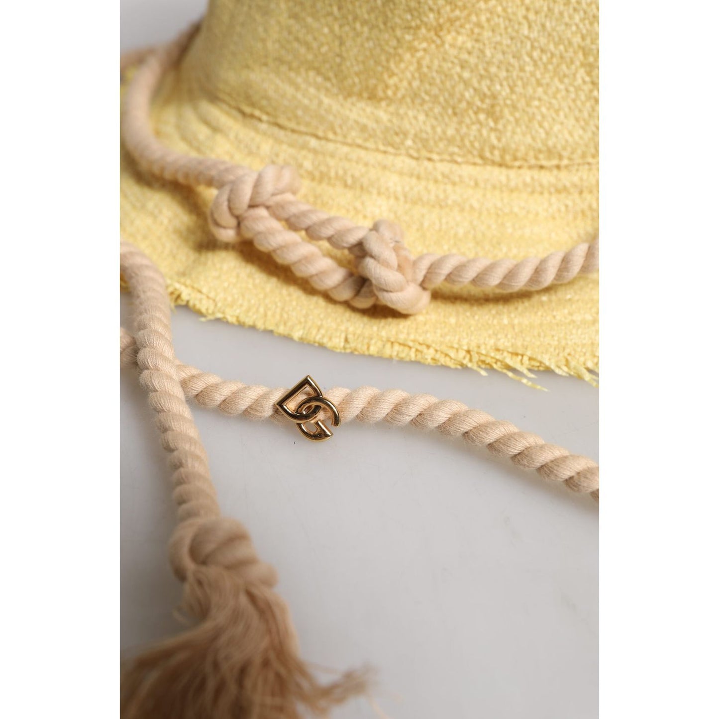 Dolce & Gabbana yellow wide brim bucket hat with braided rope detail and logo charm.