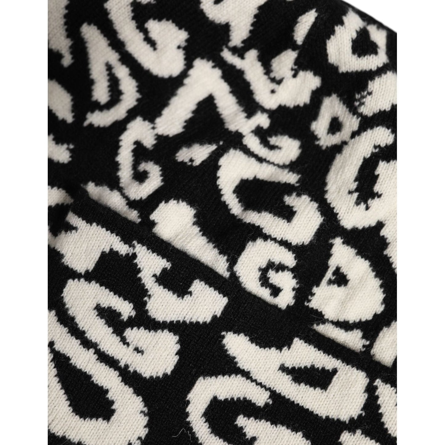 Close-up of Dolce & Gabbana black and white knitted wool beanie hat showing DG logo print in virgin wool and cashmere blend.