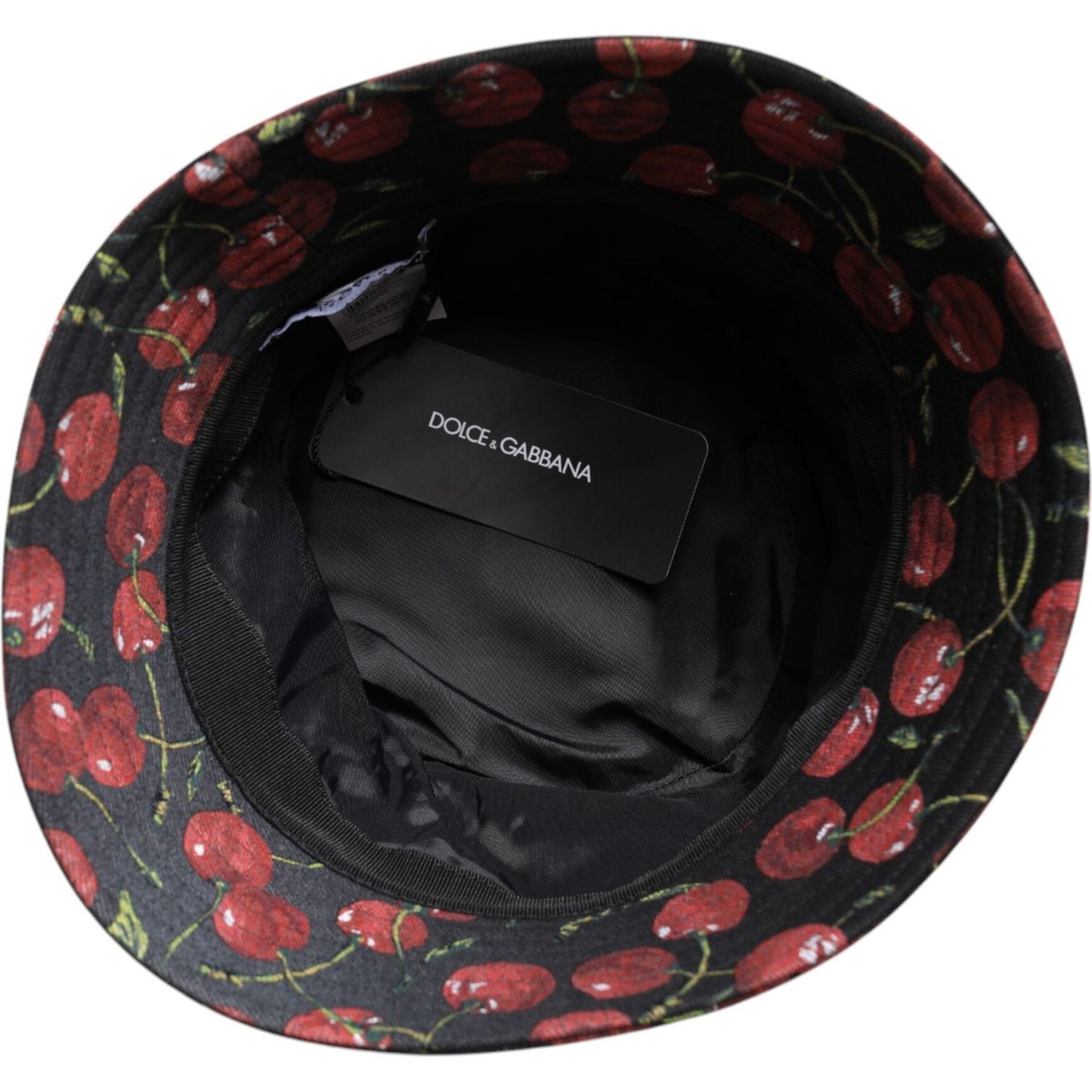 Dolce & Gabbana black cotton bucket hat with cherry print inside view; brand tag visible; designed in Italy.