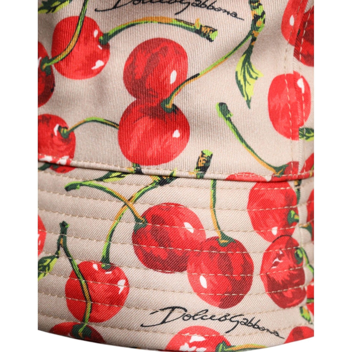 Dolce & Gabbana beige cotton bucket hat with red cherry print, wide brim, and logo detail, made in Italy.