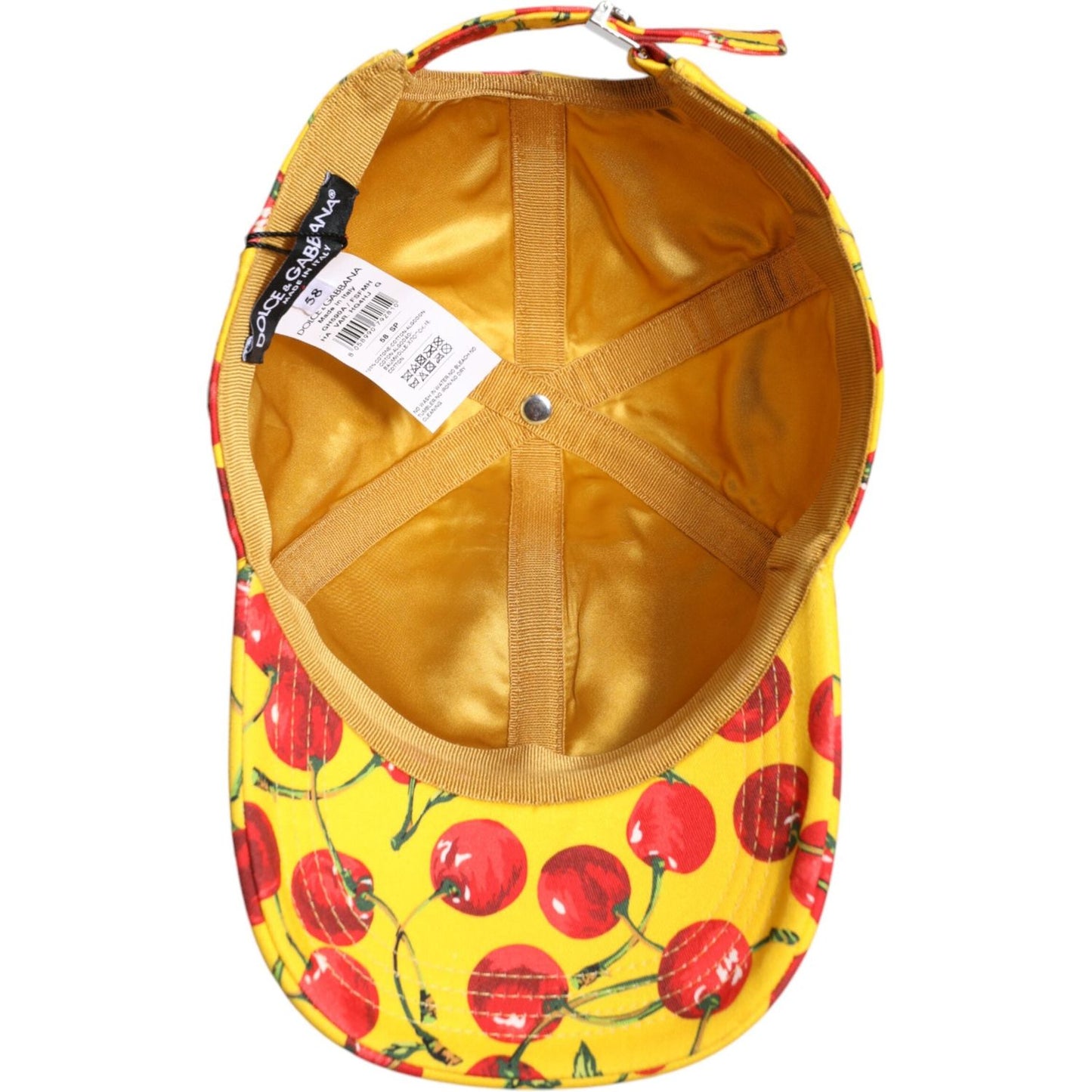 Inside view of Dolce & Gabbana yellow cotton baseball cap with cherry print, six panels, and logo tag, made in Italy.