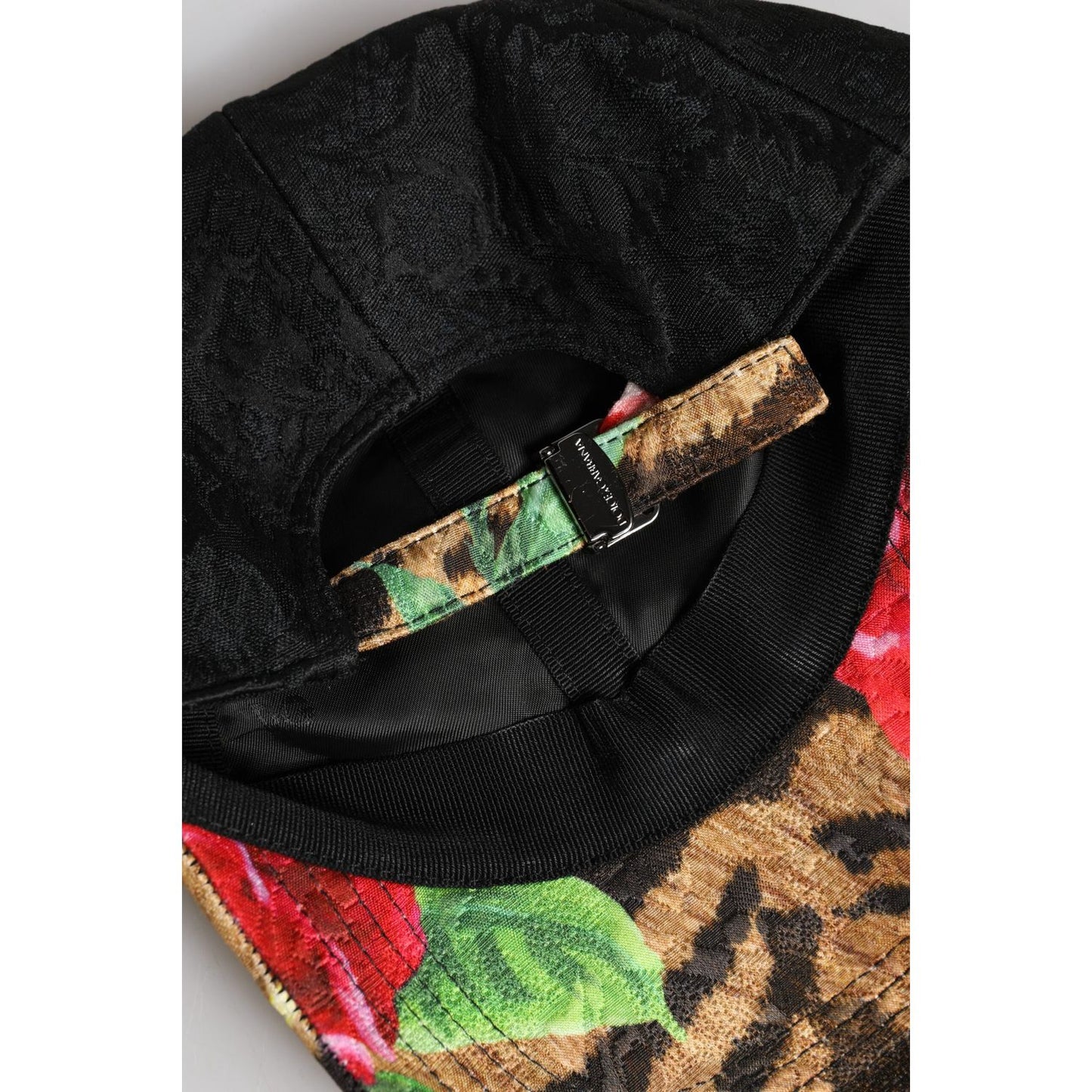 Close-up of Dolce & Gabbana multicolor baseball cap with DG logo patch, floral and animal print, adjustable strap, made in Italy.
