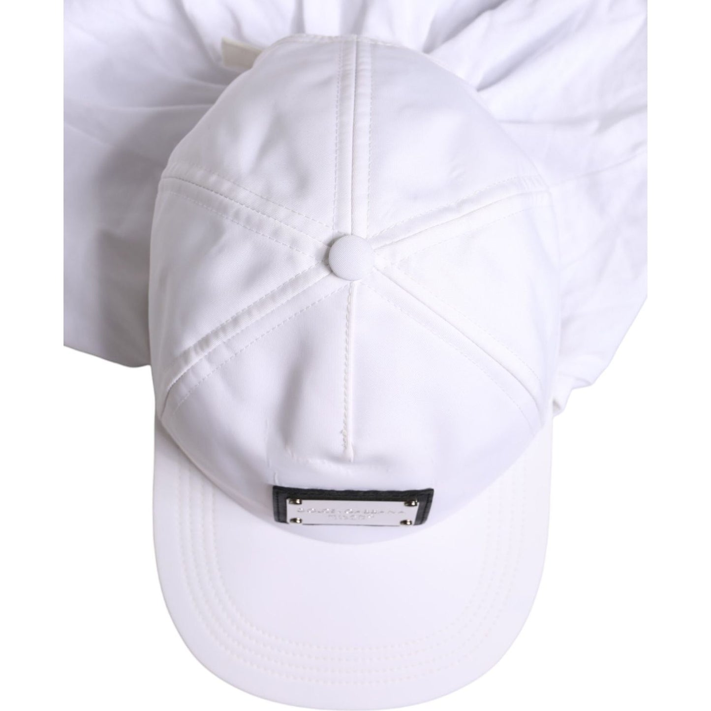 Top view of a Dolce & Gabbana white cotton baseball balaclava cap with logo plaque, made in Italy.