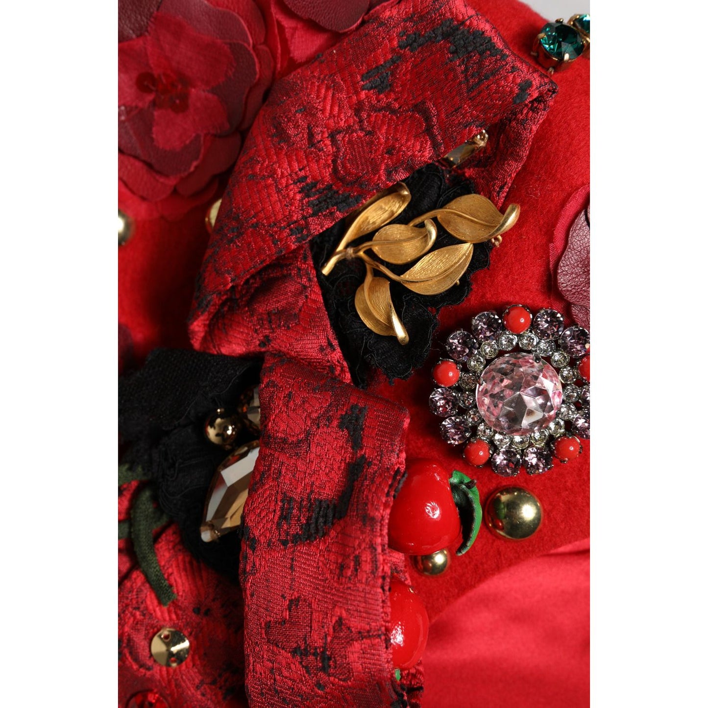 Elegant Dolce & Gabbana red cloche hat with gold roses, crystal embellishments, and silk lining, showcasing intricate details.