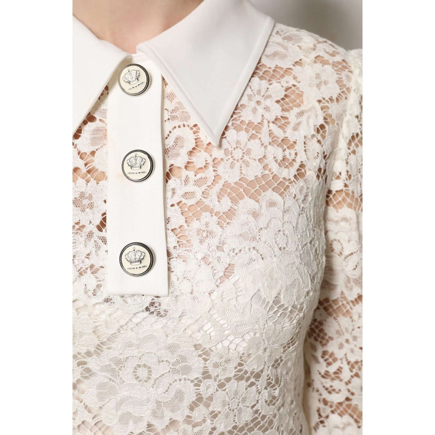 Close-up of Dolce & Gabbana white floral lace shift dress with long sleeves, featuring button details and elegant collar.