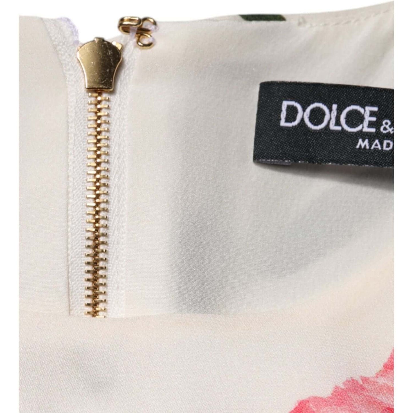 Close-up of Dolce & Gabbana pink floral dress zipper with logo tag, showing make-up stain on neckline.