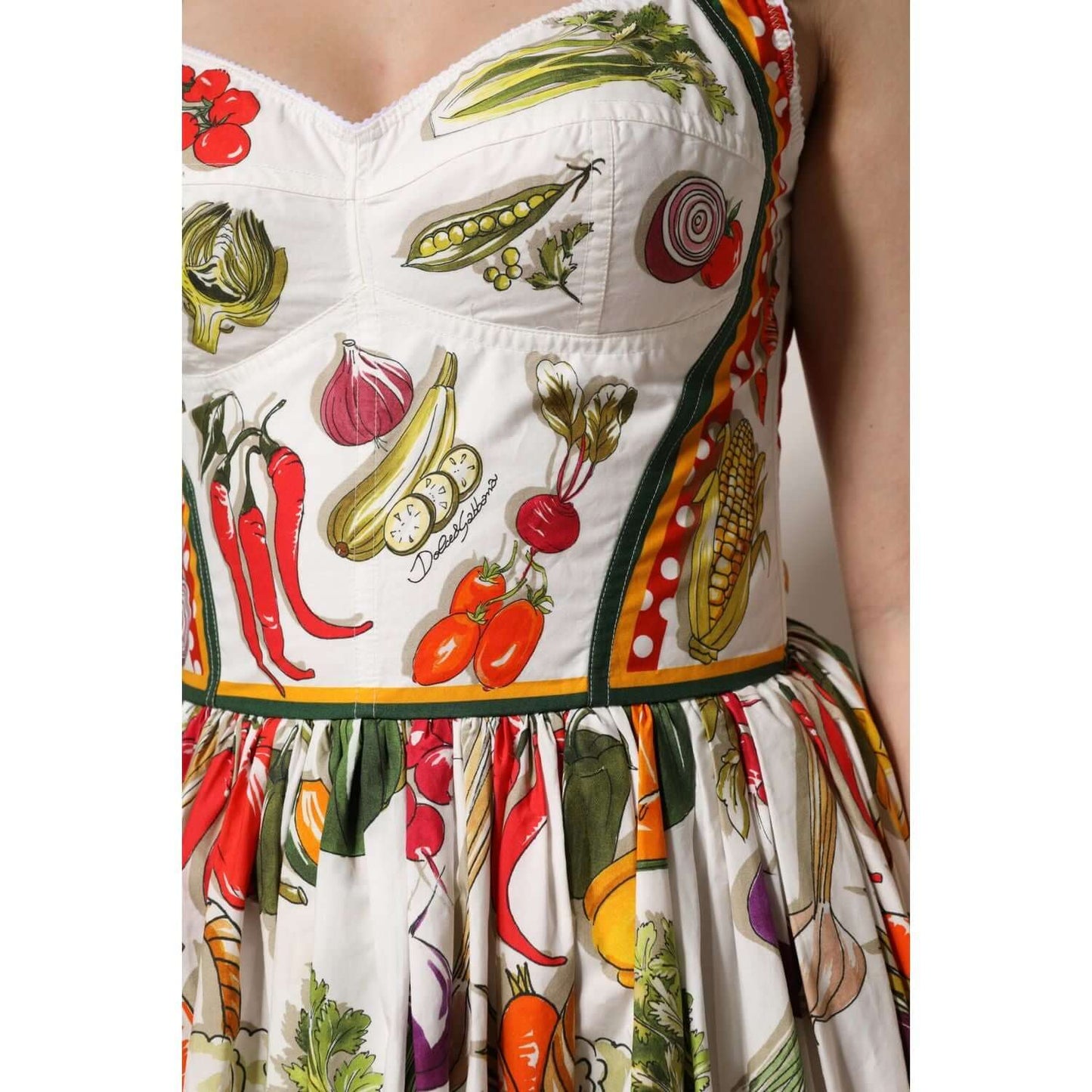 Dolce & Gabbana sleeveless midi dress featuring colorful vegetable print on white cotton, crafted in Italy, elegant A-line design.