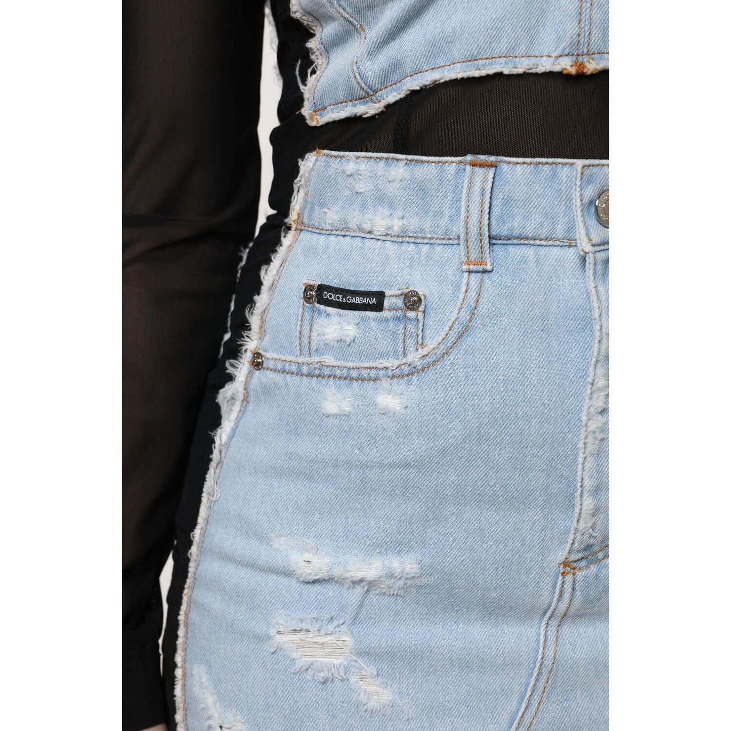 Close-up of Dolce & Gabbana black and blue denim mini dress with logo detail, featuring distressed texture and zipper closure.