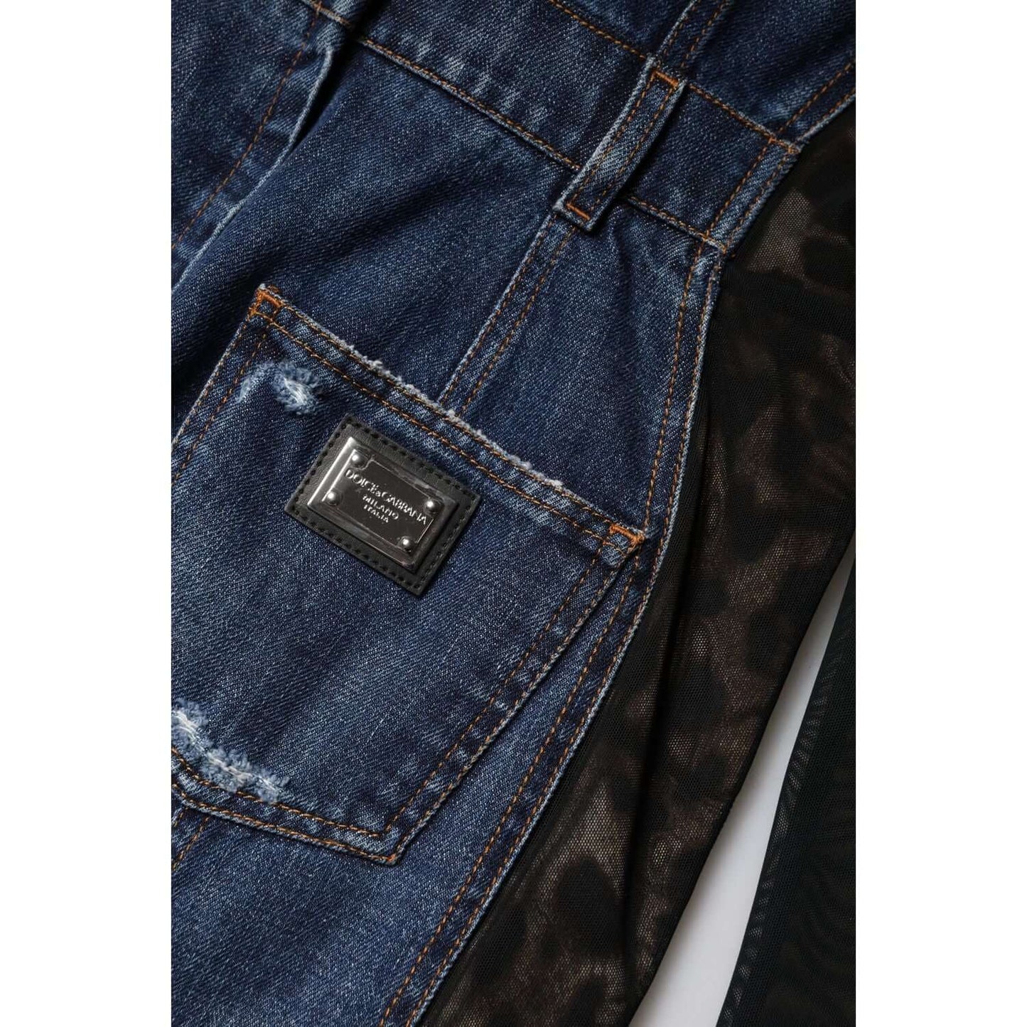 Close-up of Dolce & Gabbana blue denim mini dress with pocket and logo patch, showcasing high craftsmanship.