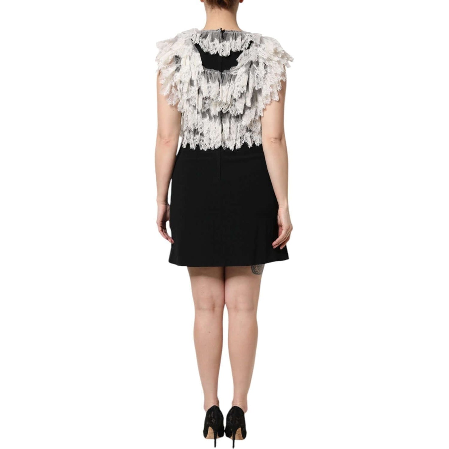Back view of Dolce & Gabbana black Devotion mini dress with embellishments, showcasing sheer lace details and high craftsmanship.