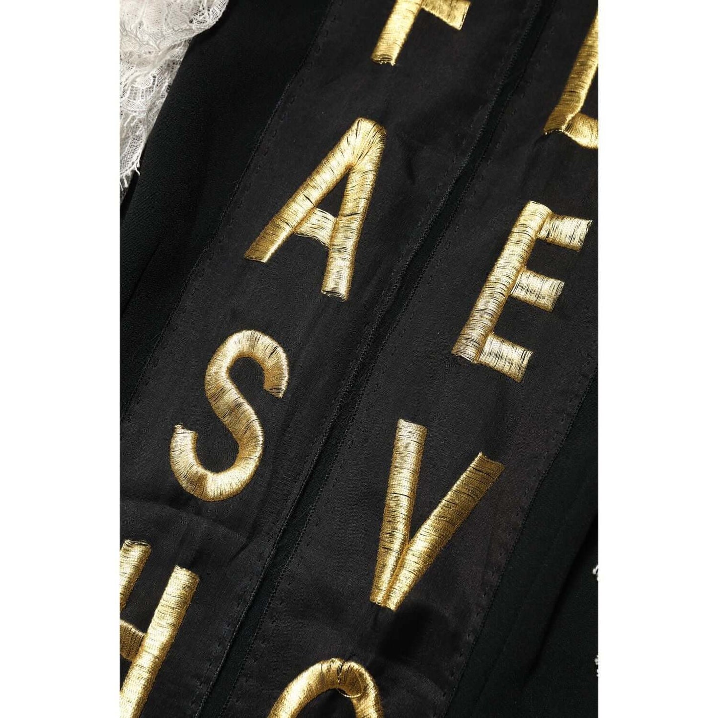 Close-up of Dolce & Gabbana Black Fashion Devotion Mini Dress with gold embellished lettering detail on luxurious fabric.