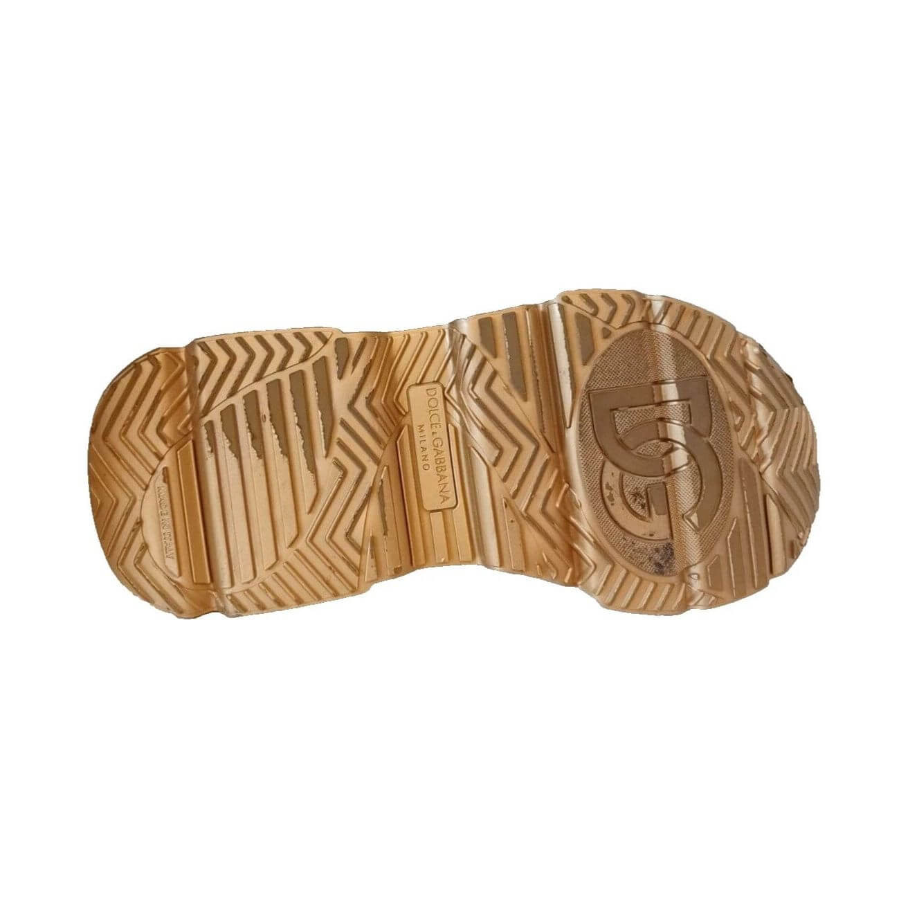 Sole view of Dolce & Gabbana Daymaster sneakers in gold with logo and textured rubber design, showcasing craftsmanship.
