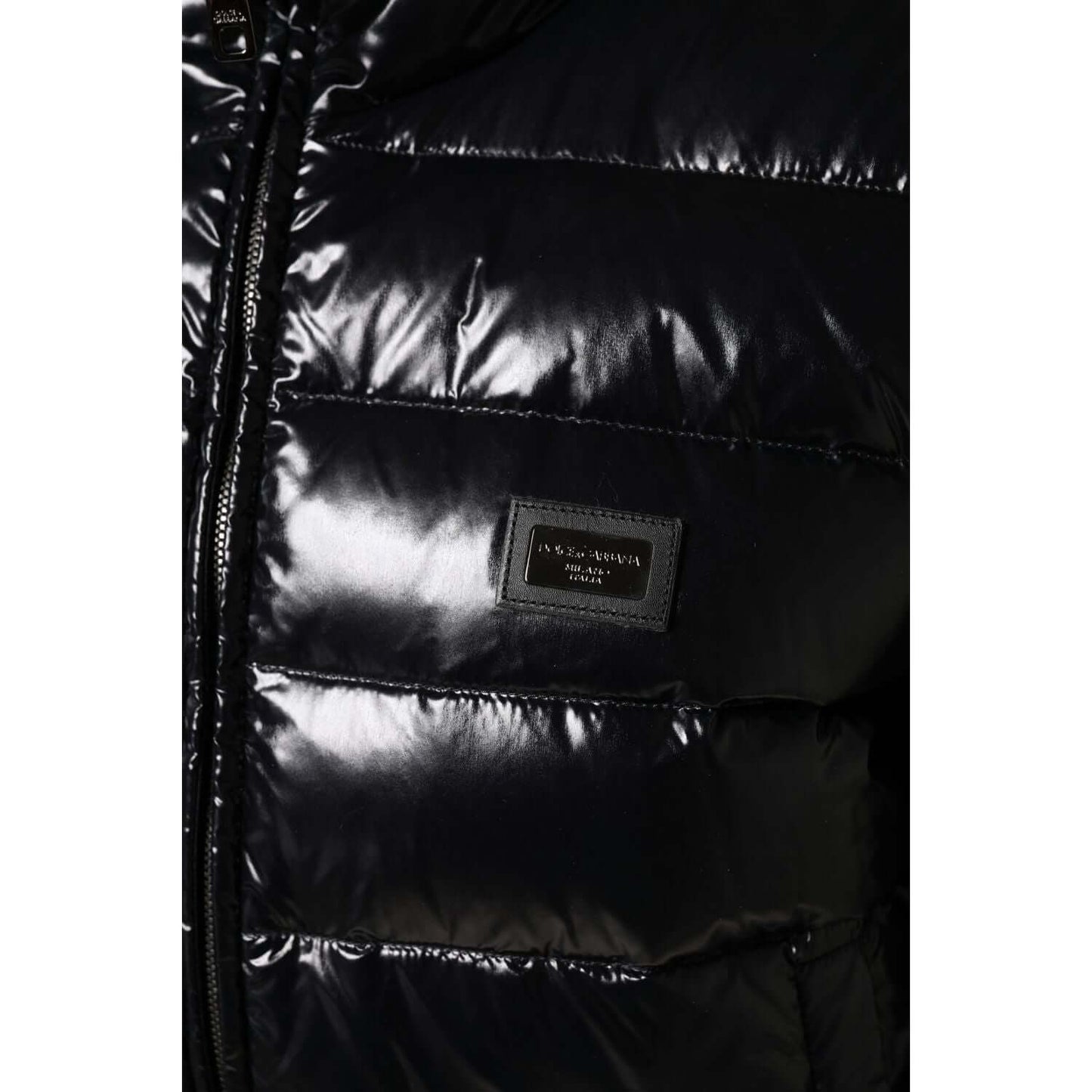 Dolce & Gabbana black puffer jacket with logo plaque, full zip closure, nylon-polyurethane blend, close-up view. Made in Italy.