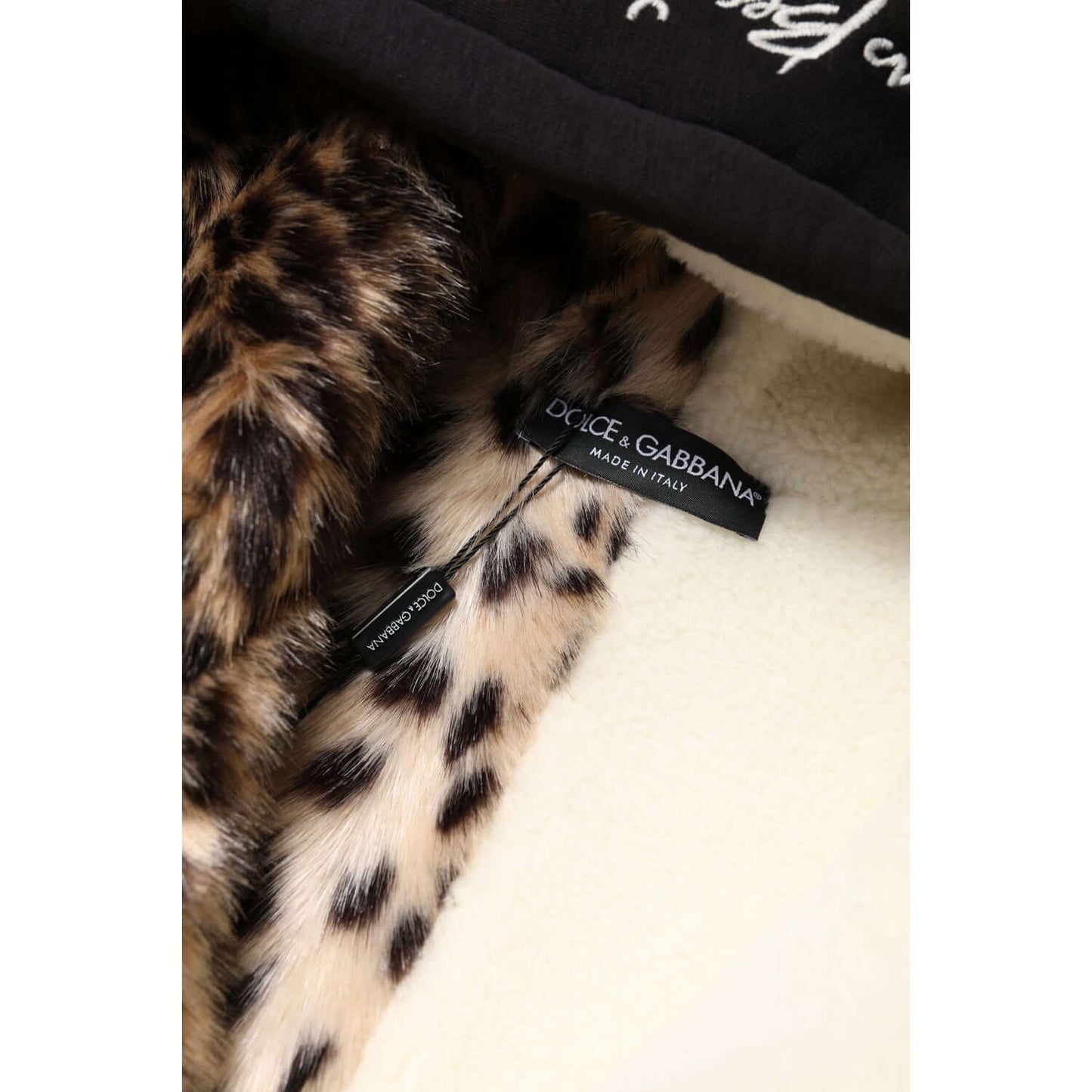 Dolce & Gabbana black hooded jacket interior with leopard print detail and logo tag, showcasing high craftsmanship and luxury fashion.