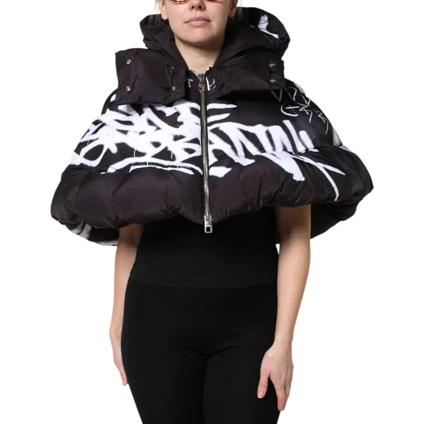 Dolce & Gabbana black padded hooded cropped jacket with graffiti print, shown on model. Full zip closure, Italian craftsmanship.