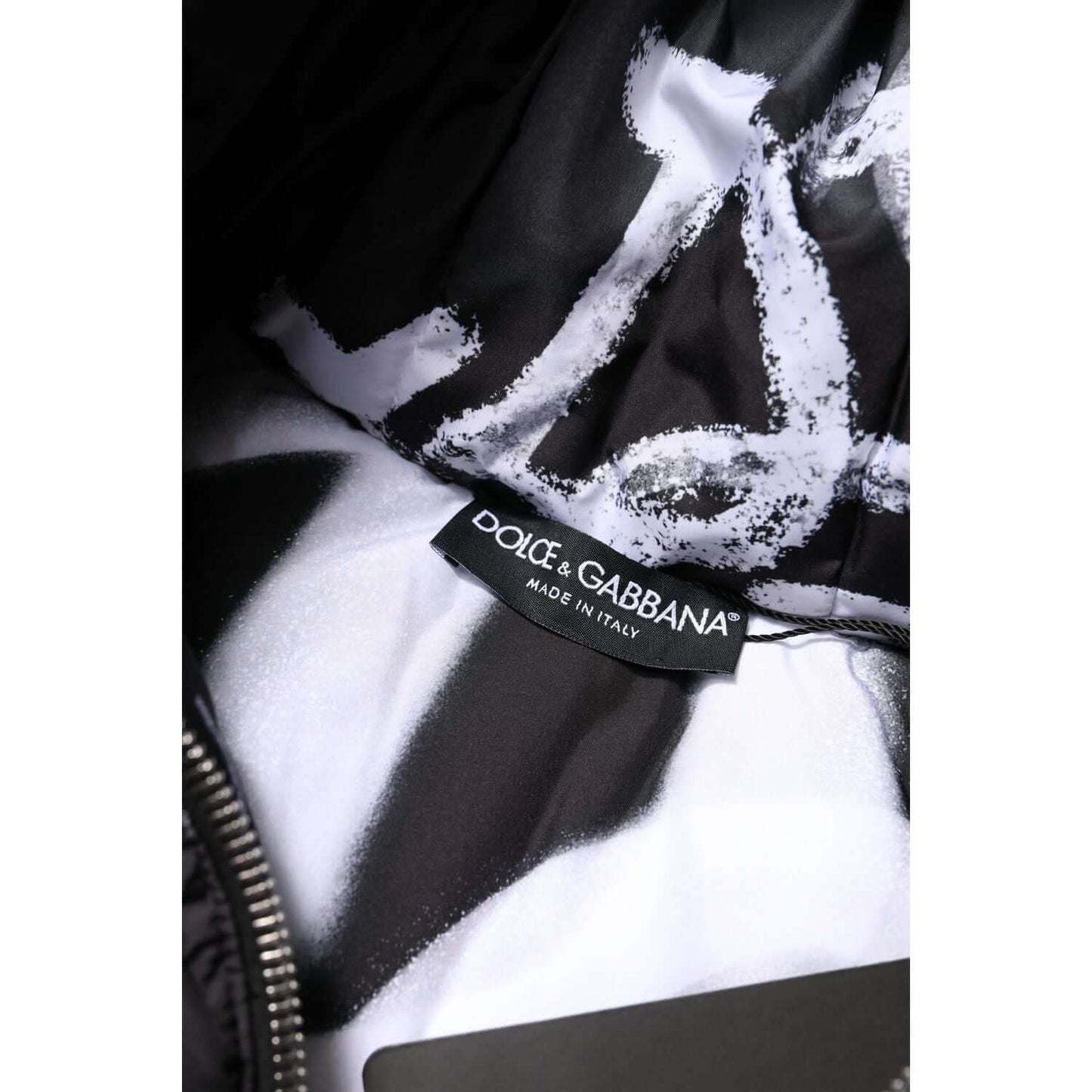 Dolce & Gabbana label inside black padded hooded jacket, showing logo, made in Italy, on black and white lining.