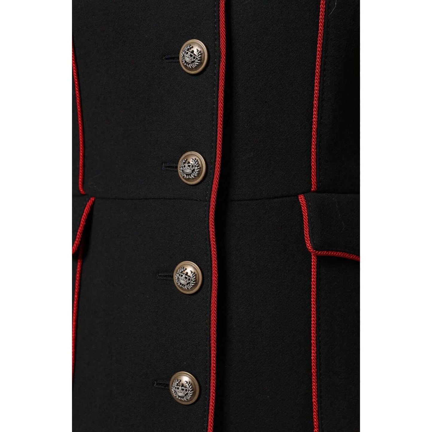 Close-up of Dolce & Gabbana black wool trench coat with red trim and designer buttons, showcasing craftsmanship and luxury details.