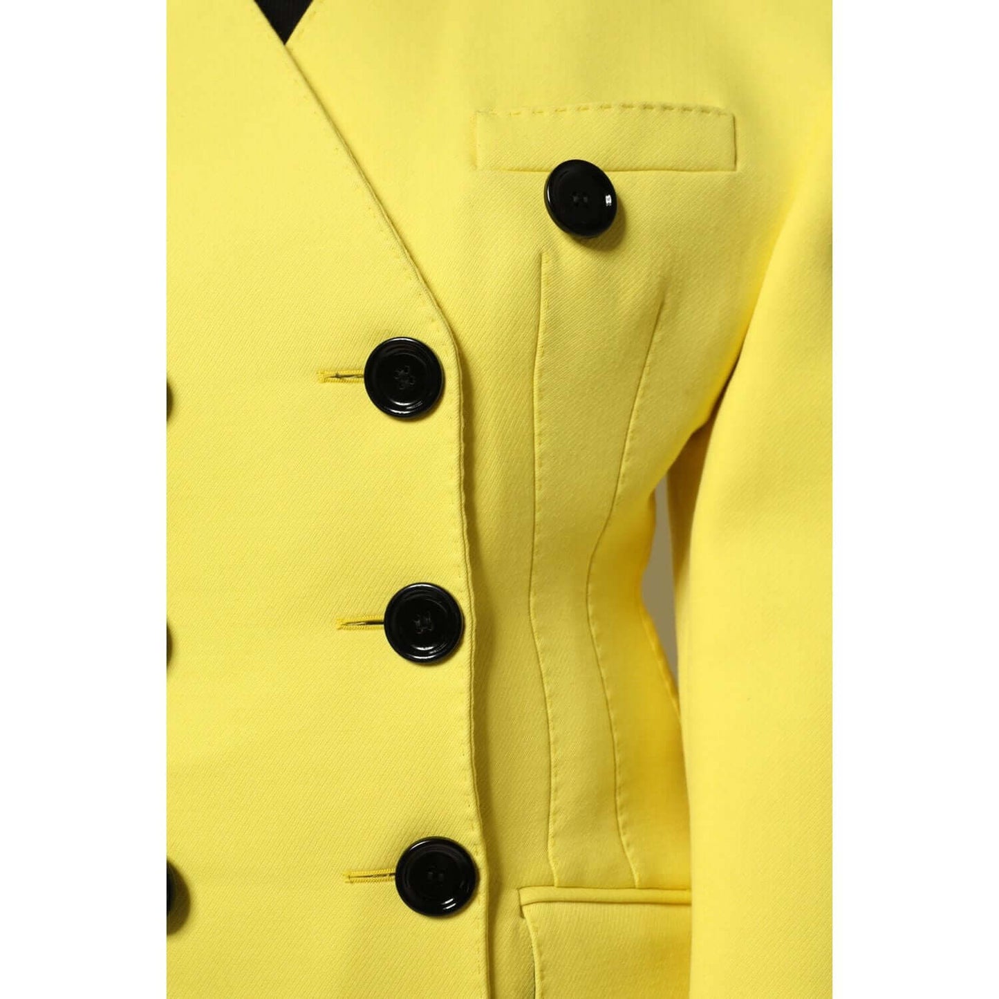 Dolce & Gabbana yellow double-breasted trench coat jacket with black buttons, crafted from virgin wool, close-up view.