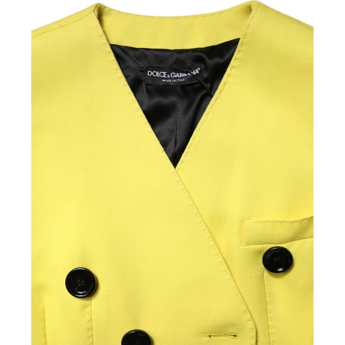 Dolce & Gabbana yellow double-breasted trench coat jacket showcasing black buttons and logo, luxury fashion made in Italy.